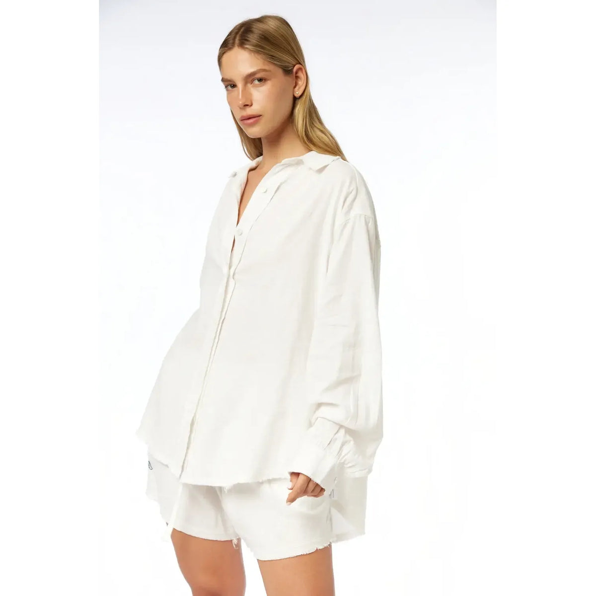 Woman wearing a white oversized linen button-down shirt and matching shorts