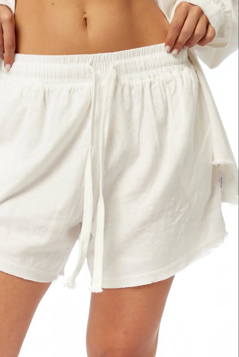 Pure Linen Women's Shorts in white, with a drawstring waist and frayed hem, worn by a person