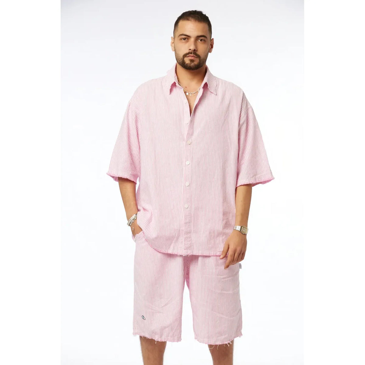 Man wearing a pink striped linen short sleeve button-up shirt and matching shorts
