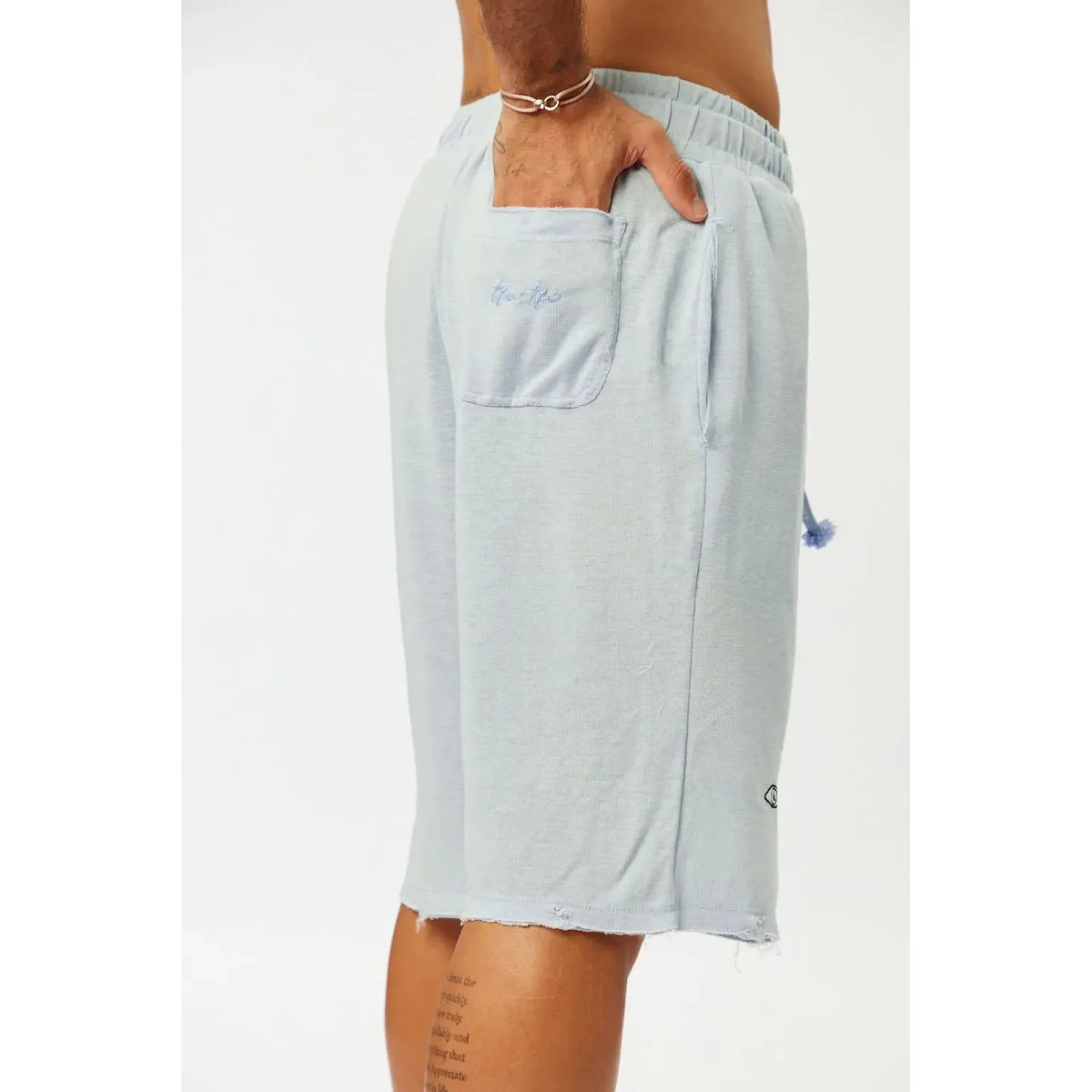 BASE Shorts in light blue, with a hand in the back pocket