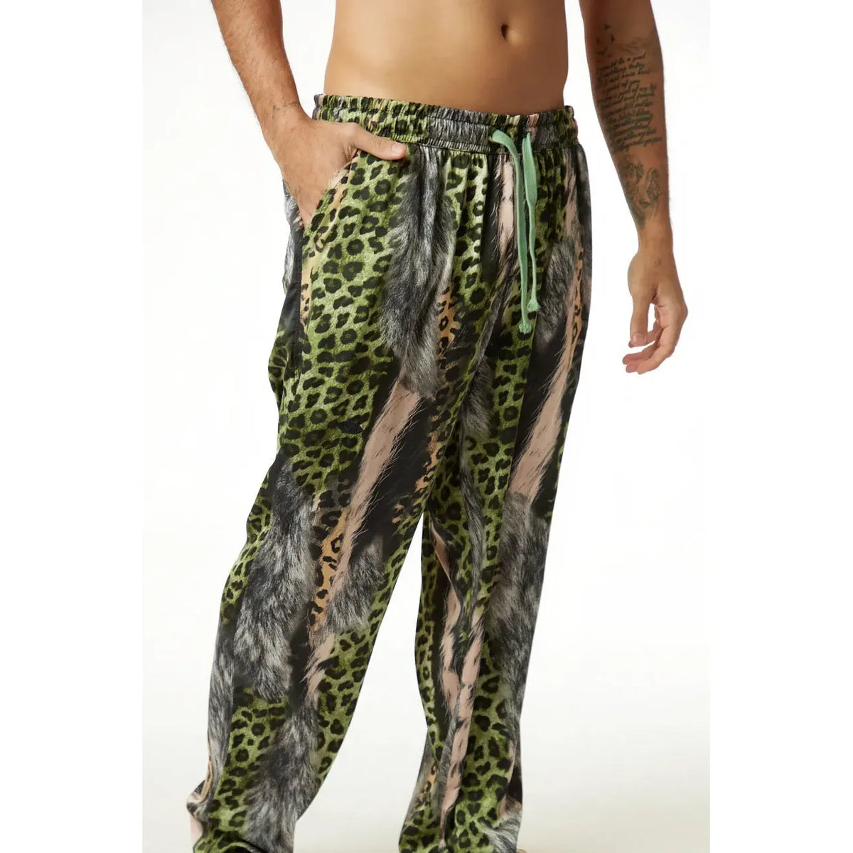 Wild Satin Leopard Pants with green drawstring on a person with a tattooed arm