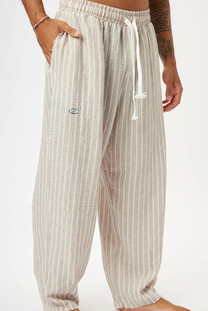 Pure Oversized Linen Pants in Stone & White Stripes, with a drawstring waist and a small eye logo on the left leg