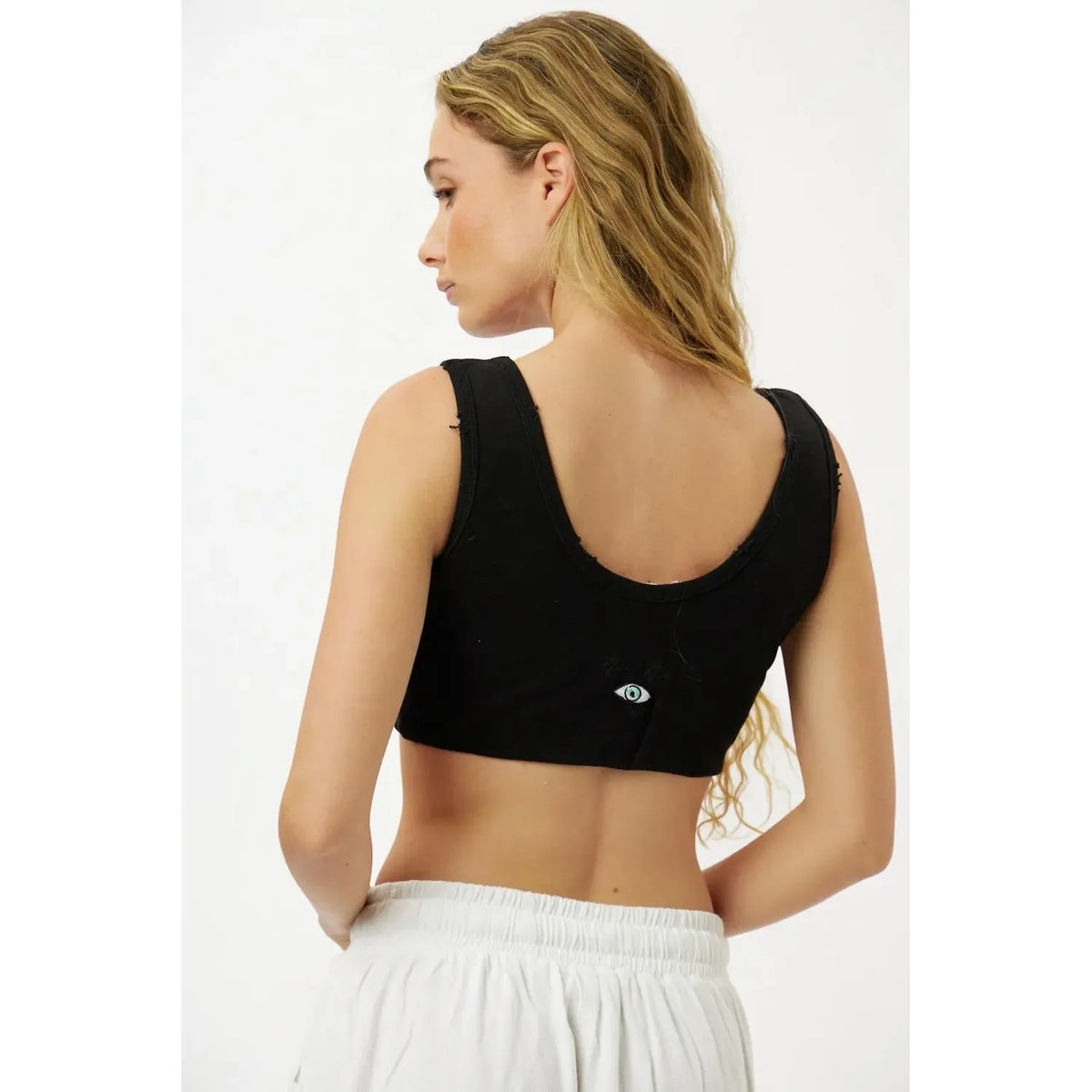 Essential Crop Top - Black, back view, with an eye graphic on the lower back