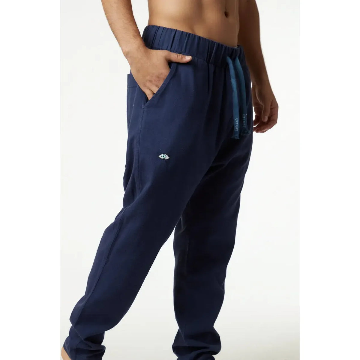 DC Fisherman Pants in blue, with a drawstring waist and an eye logo on the left leg