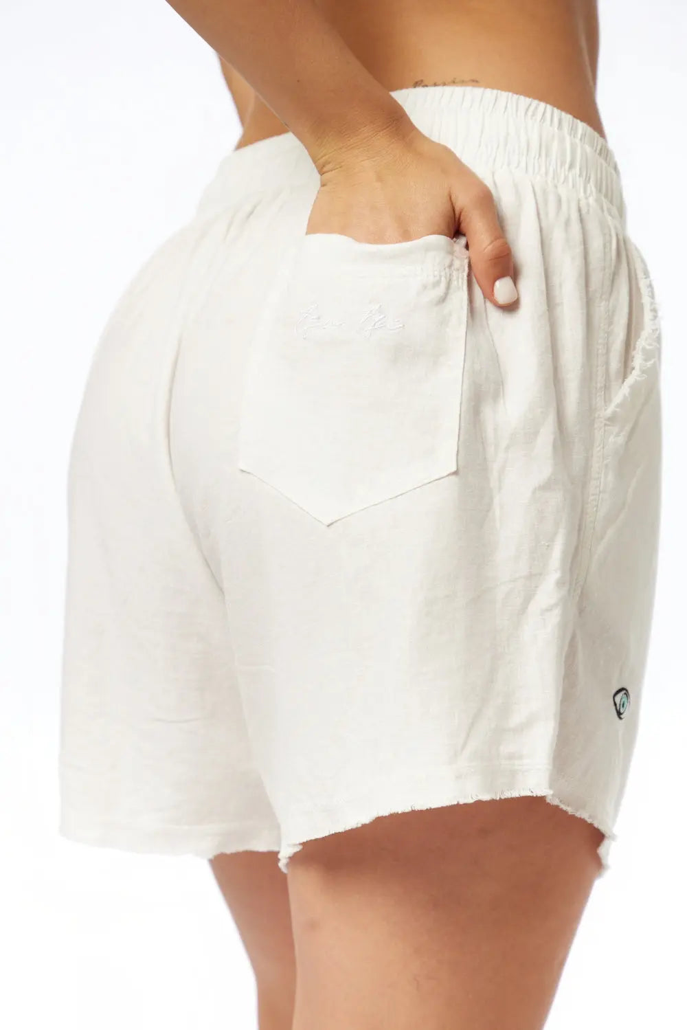 Close up of Pure Linen Women's Shorts in white, showing the back pocket with embroidered logo and elastic waistband