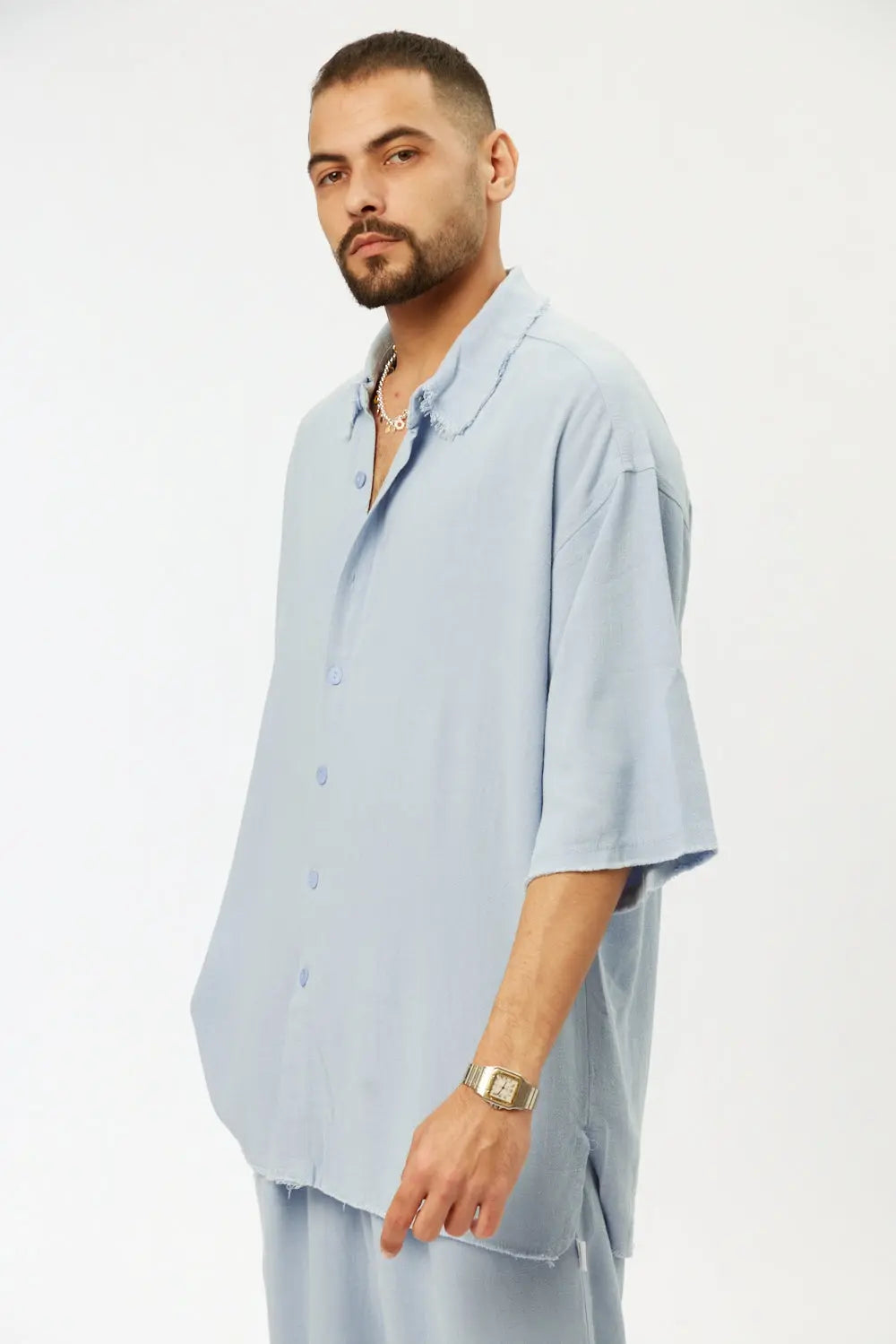 Man wearing a sky blue short sleeve linen shirt and matching bermuda shorts
