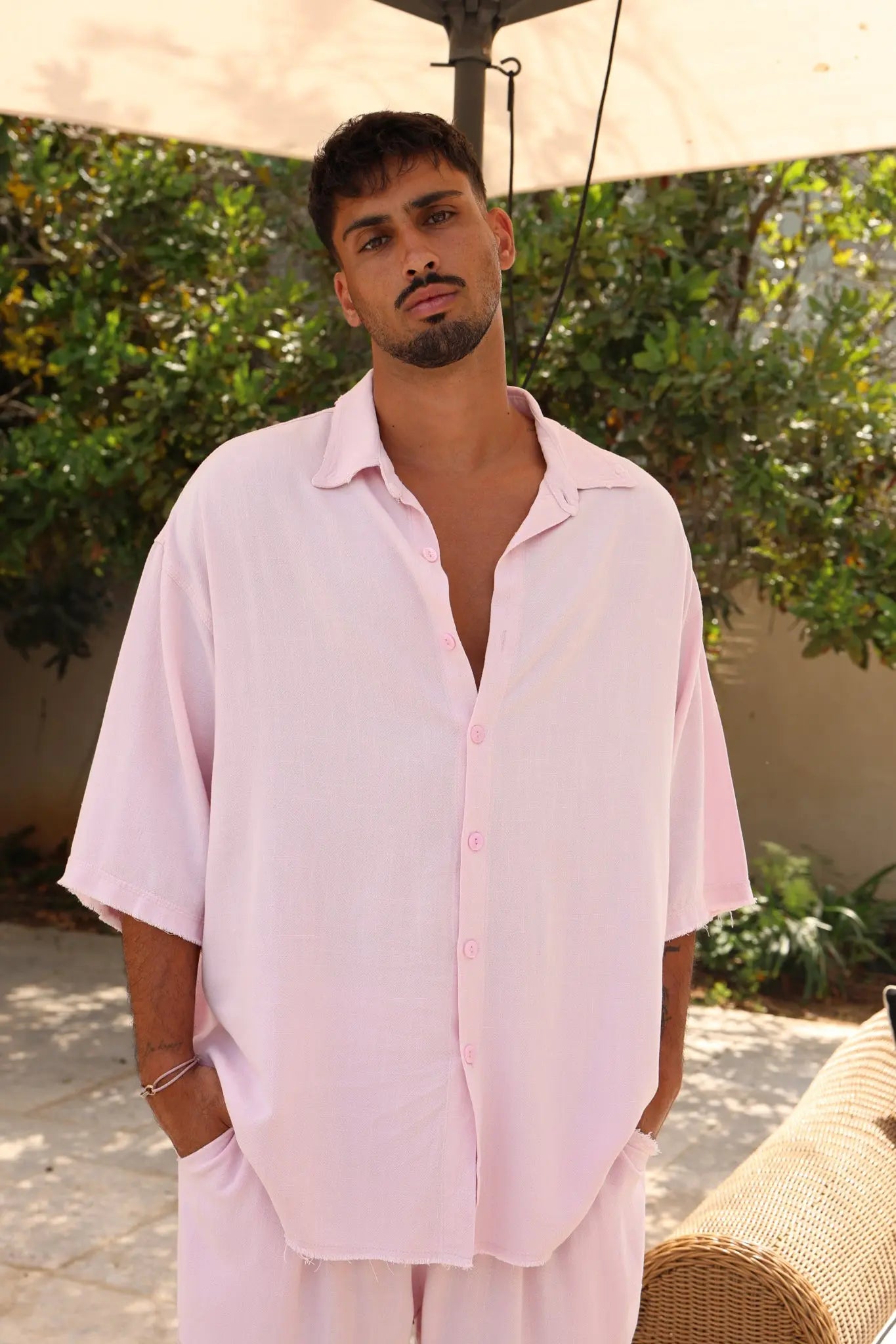 Man wearing a Soft Linen Set in Baby Pink, featuring a short sleeve shirt and Bermuda shorts