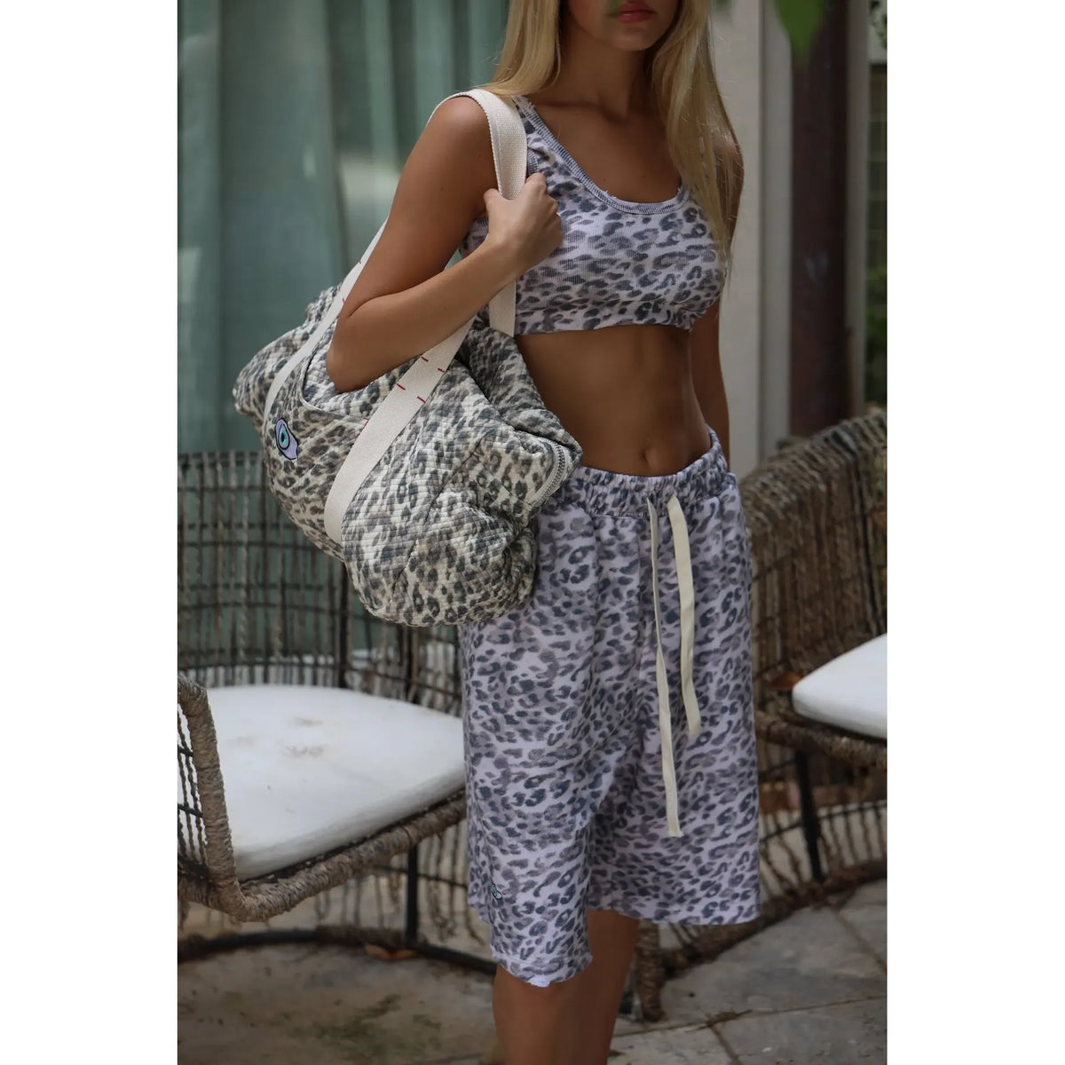 Woman wearing a leopard print crop top and shorts, holding a matching leopard cotton bag over her shoulder