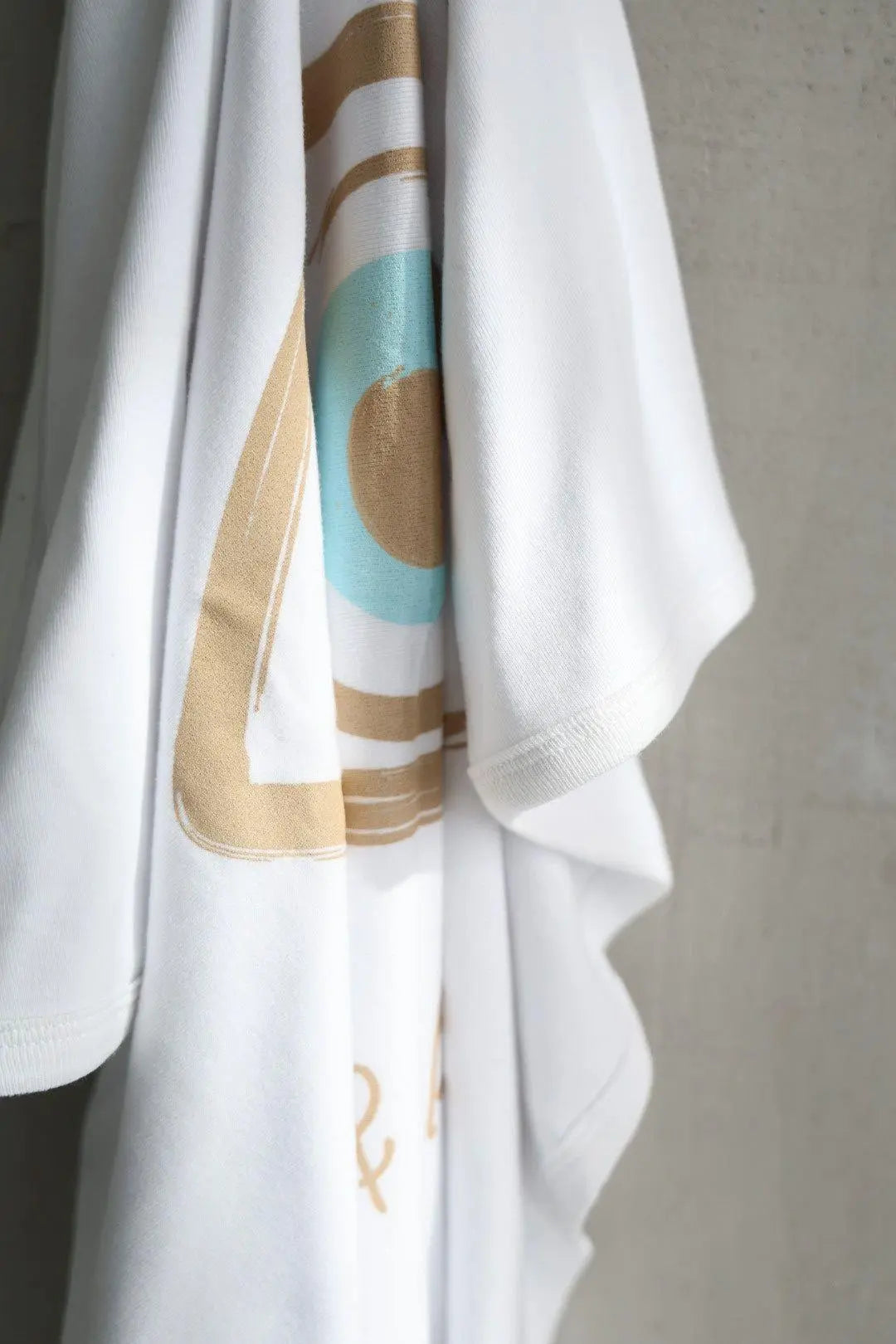 White garment with abstract patterns on a gray background