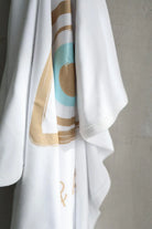 White garment with abstract patterns on a gray background