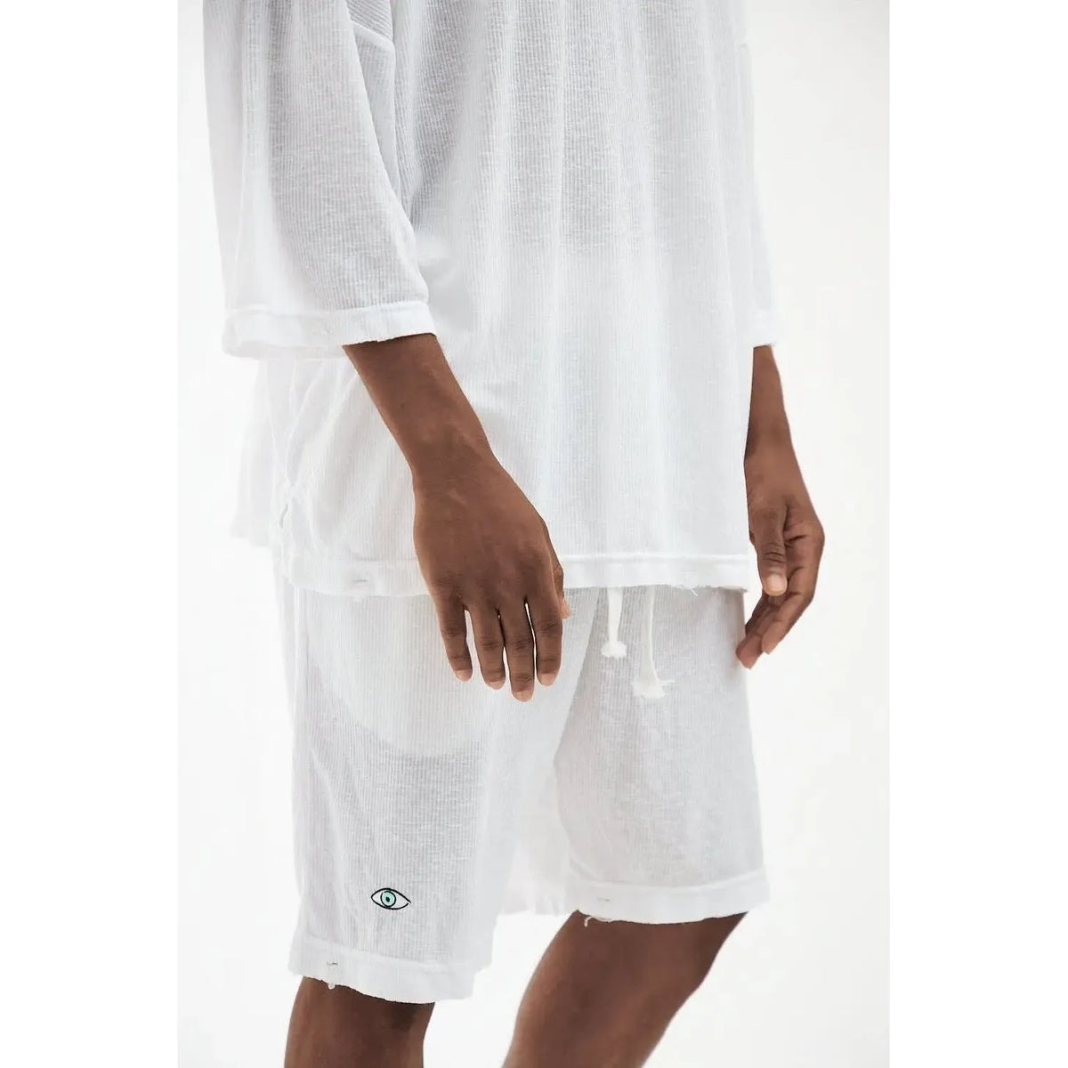 Rib Bermuda Shorts in white with a small eye logo on the left leg