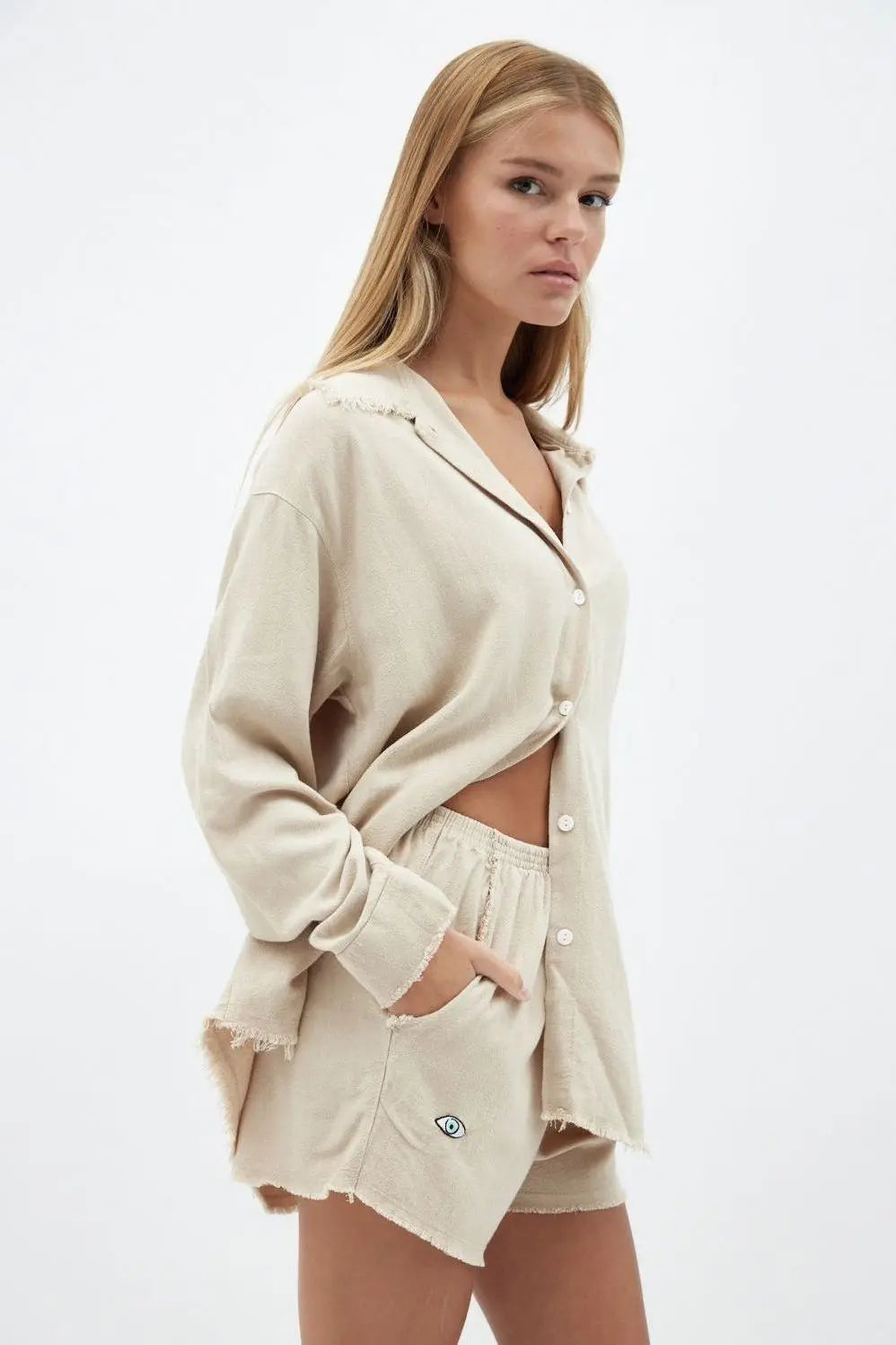 Soft Linen Shorts in beige on a model, paired with a matching long-sleeve shirt