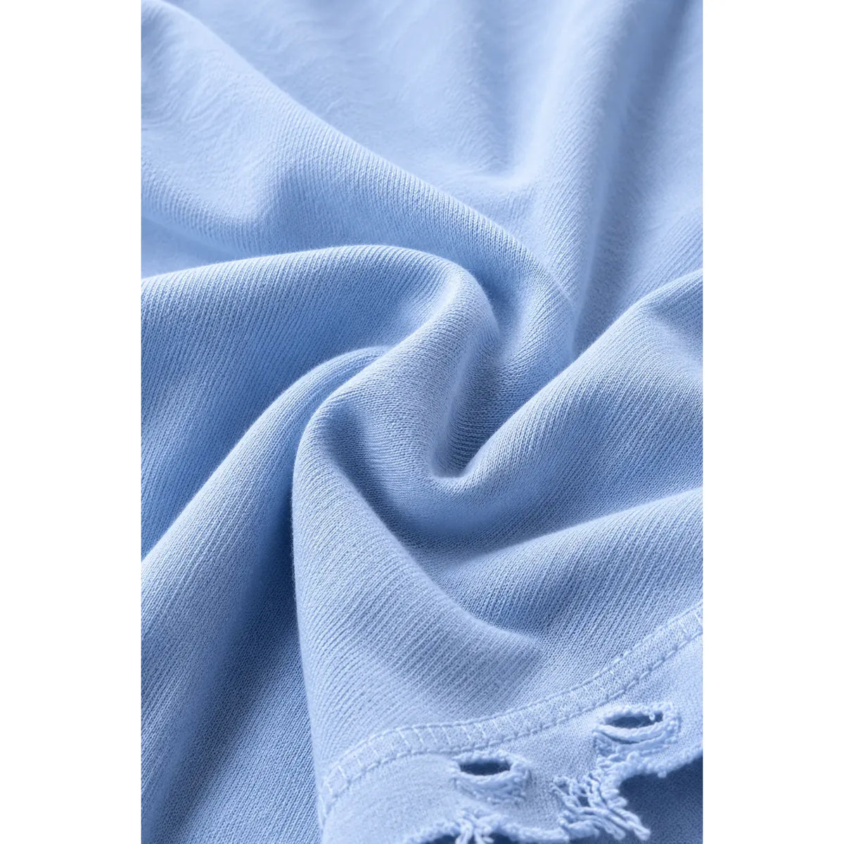 Close up of light blue Dor Oversized Shirt fabric with visible texture and distressed hem