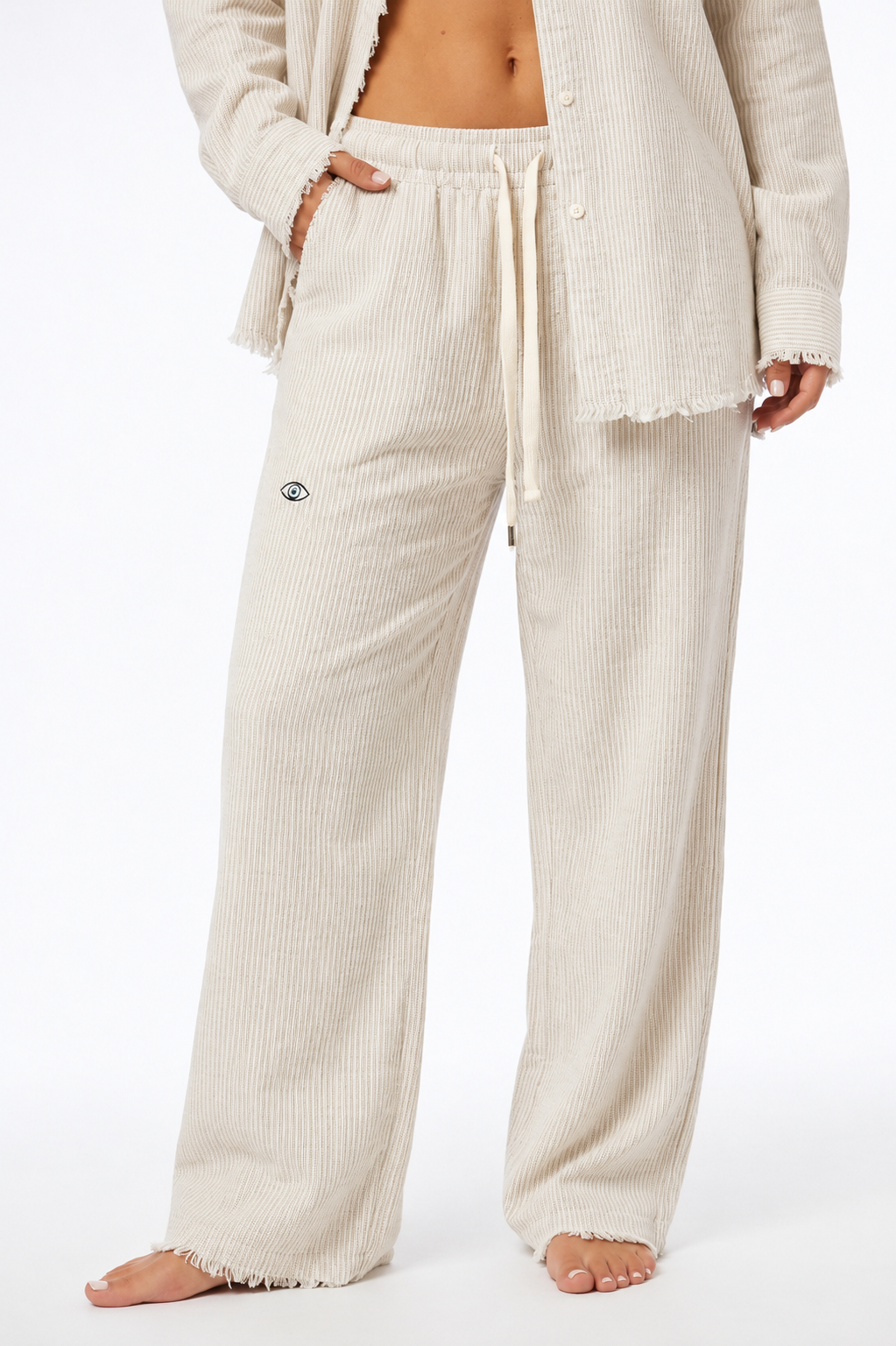 Person wearing cream ribbed lounge pants and cardigan on a white background