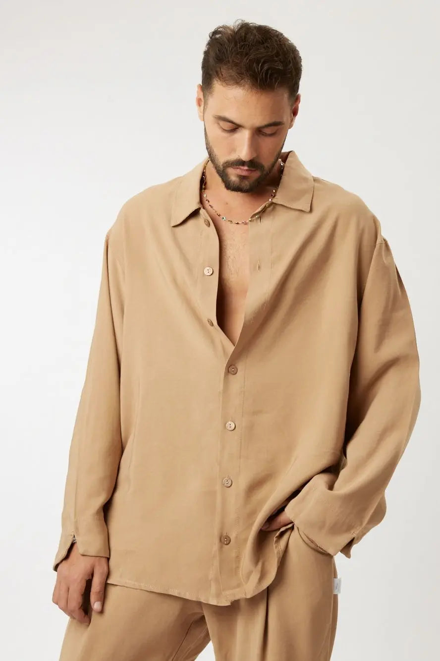 Man wearing a LUX CAMEL - SET, a camel-colored oversized button-up shirt and matching pants