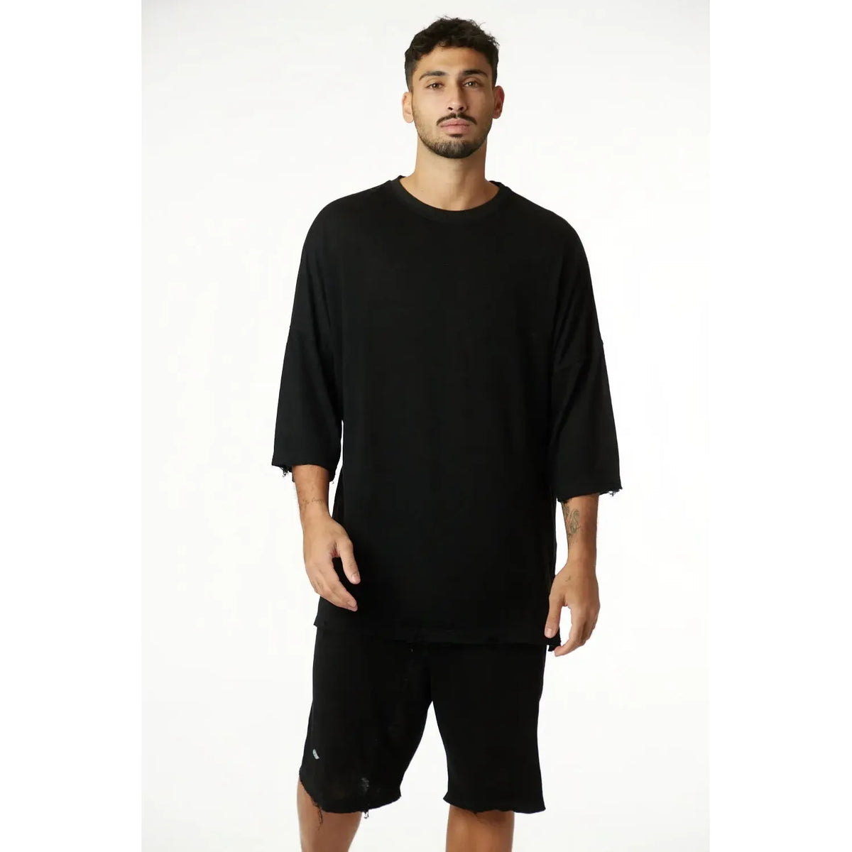 Man wearing a black 3/4 Sleeve Nicki Soft top and black shorts