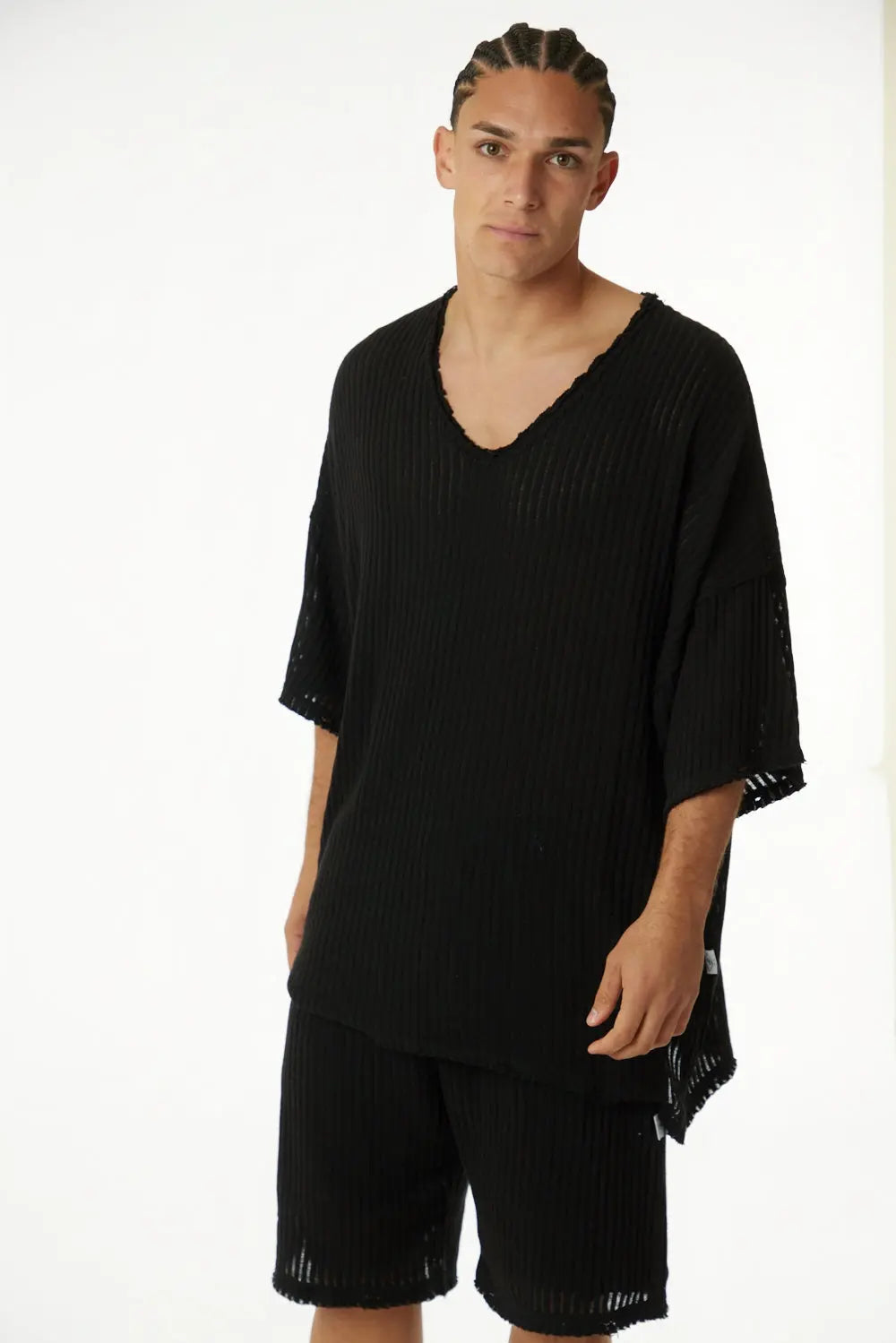Man wearing a black striped v-neck top and matching shorts from the STRIPED BLACK - SET