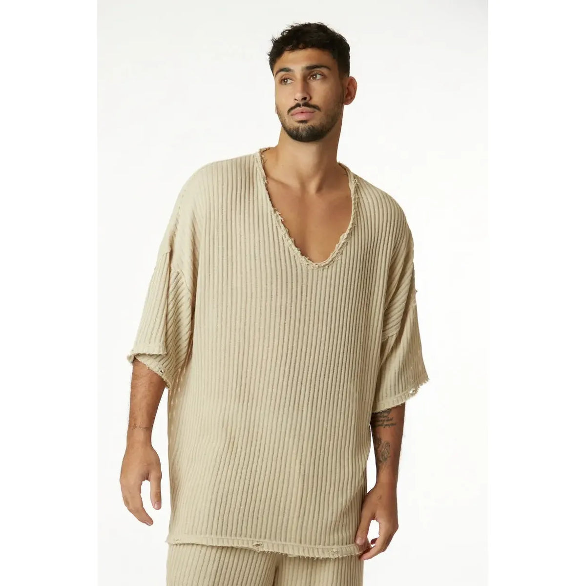 Man wearing a stone striped knit shirt with a deep V-neck and short sleeves